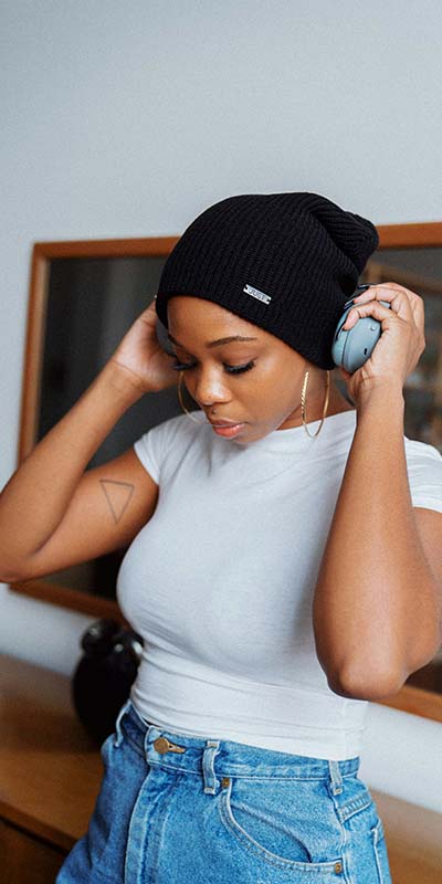 A Black woman putting on headphones, choosing music from her dopamine menu A Black woman putting on headphones, choosing music from her dopamine menu