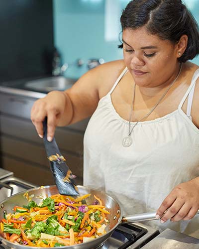 A woman cooking a stir-fry after choosing cooking from her dopamine menu to help with her executive functioning and task inertia A woman cooking a stir-fry after choosing cooking from her dopamine menu to help with her executive functioning and task inertia