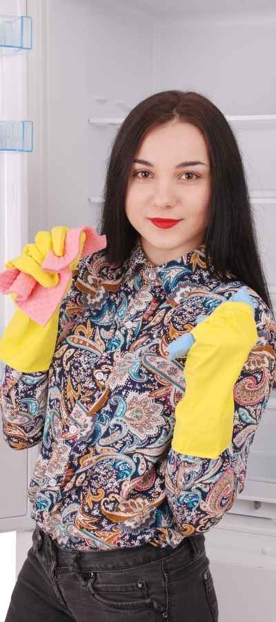 A woman deep cleans her fridge rather than begin her tasks due to executive function barriers A woman deep cleans her fridge rather than begin her tasks due to executive function barriers