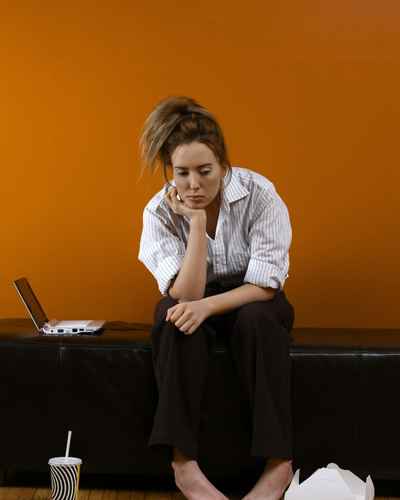A woman sits next to her laptop, unable to user her executive functioning skills for task initiation A woman sits next to her laptop, unable to user her executive functioning skills for task initiation