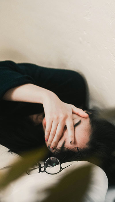An exhausted woman laying down after struggling with communication all day An exhausted woman laying down after struggling with communication all day