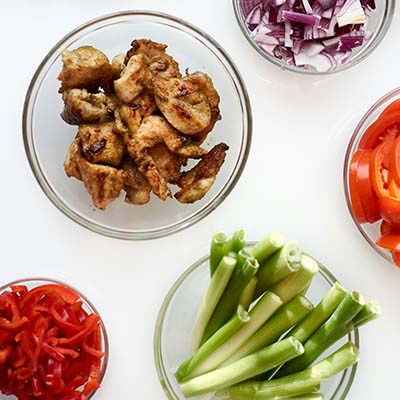 Food in small glass bowls during food prep for a busy week