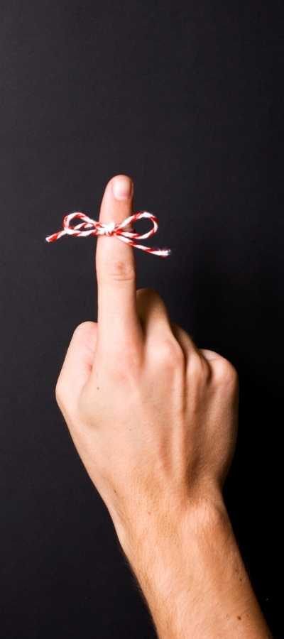 A finger with a string tied in a bow around it indicating a reminder to follow through