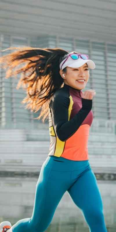 A woman jogging with headphones in to keep her senses engaged during her ADHD workouts