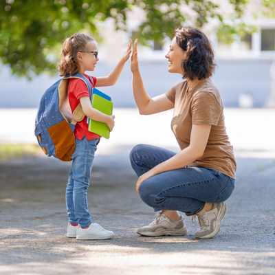 A woman gives a high five to a child celebrating overcoming executive functioning challenges A woman gives a high five to a child celebrating overcoming executive functioning challenges