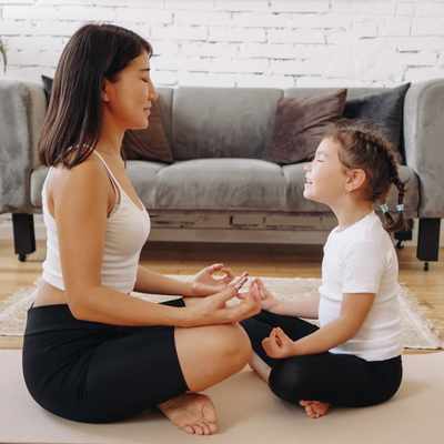 A woman models meditation and grounding practices with a child to help with struggles with executive functioning A woman models meditation and grounding practices with a child to help with struggles with executive functioning