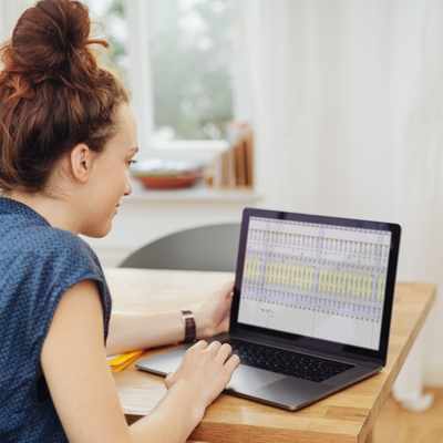 A woman words on a spreadsheet on her laptop