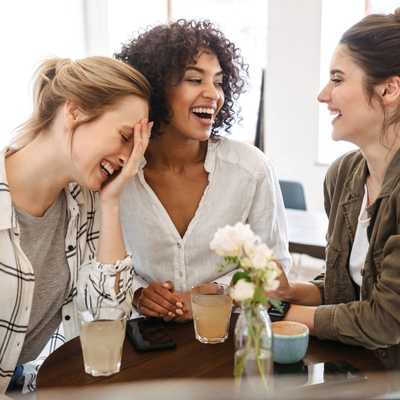 A group of 3 women laughing together and relaxed A group of 3 women laughing together and relaxed