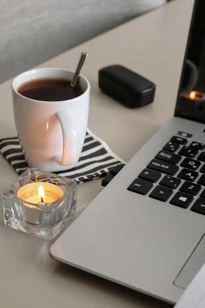 Tea and a candle next to a laptop to initiate a productivity ritual and start a micro-challenge