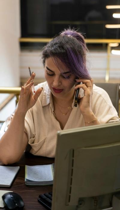 A woman uses written notes to stay focused when a phone call interrupts her