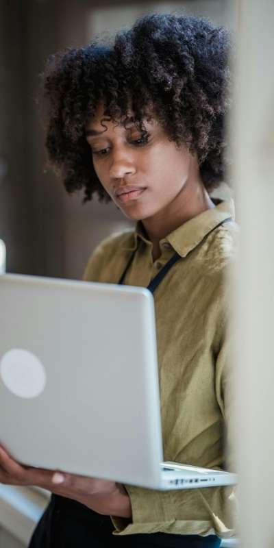 A Black person working on a laptop trying to move between knowing and doing the tasks they need to accomplish