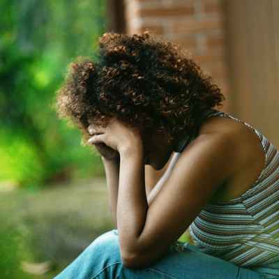 A woman sits with her head in her hands fighting ADHD shame due to executive dysfunction struggles